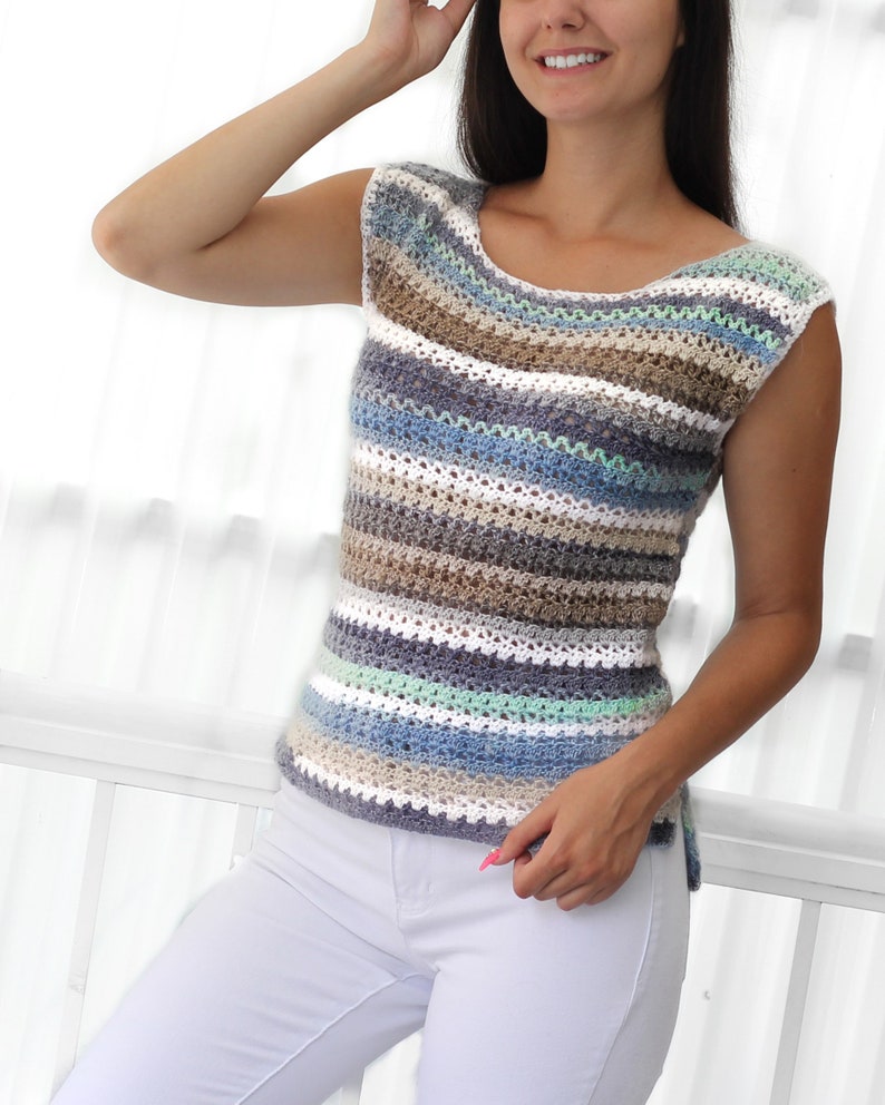 May include: A striped crochet top with a scoop neck and sleeveless design. The top is made with a variety of colors, including white, blue, green, and brown.