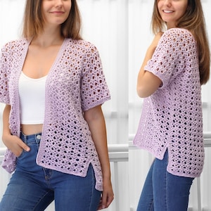 May include: A light purple crochet cardigan with a loose fit and short sleeves. The cardigan has a delicate openwork pattern and a slightly longer back hem.