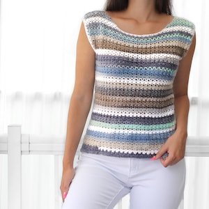 May include: A striped crochet top with a scoop neck and short sleeves. The top is made in a variety of shades of blue, brown, white, and green.