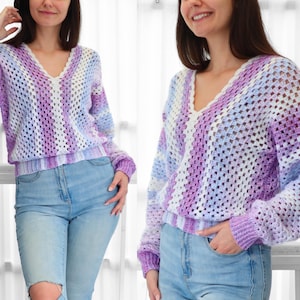 Pode incluir: Um su&eacute;ter de croch&ecirc; listrado em roxo, branco e azul com decote em V.