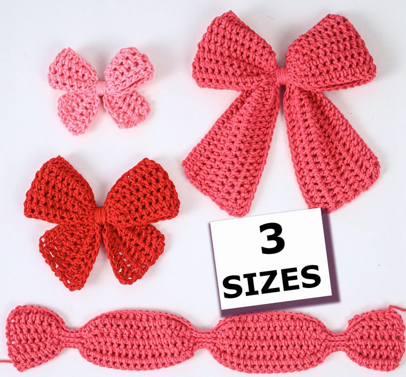 May include: Three crocheted bows in varying shades of pink and red, arranged with a small light pink bow, a medium red bow, and a large dark pink bow. A white square card with the black text 3 SIZES is positioned near the bows.