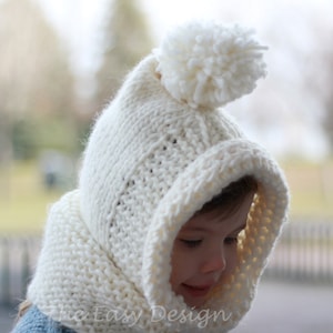 May include: White knitted hooded hat with a pom pom on top. The hat has a wide brim and a scarf attached to the neck.