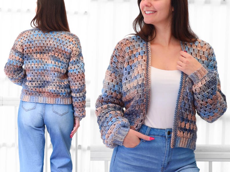 May include: A multi-colored, open-front crochet cardigan in shades of blue, tan, and brown. The handmade sweater has long sleeves and a cropped length. The open weave design is visible. The model is wearing blue jeans and a white top.