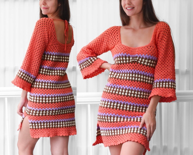 May include: A crocheted dress with a striped pattern in shades of orange, brown, purple, and white. The dress has a scoop neck, long sleeves, and a side slit.