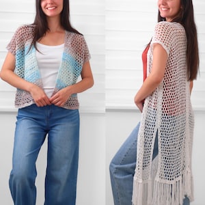 May include: A short-sleeved, open-front crochet cardigan featuring a multi-colored gradient pattern of brown, blue, and white, paired with a long, sleeveless, white crochet duster vest with side slits and a fringed hemline.