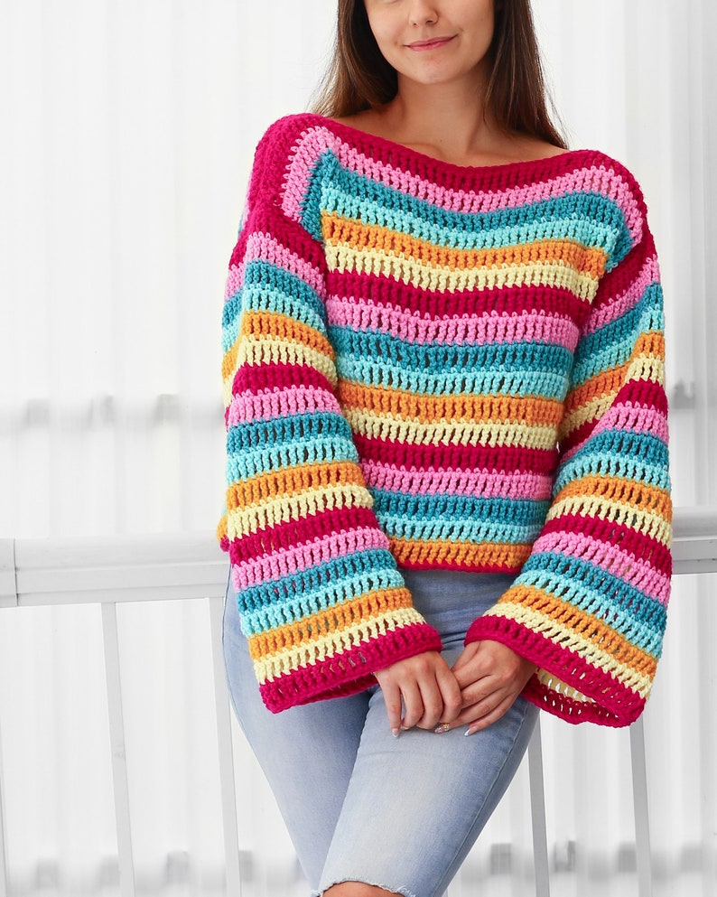 Peut inclure: Un haut en crochet ray&eacute; color&eacute; &agrave; manches longues et &agrave; col large. Le haut est fait dans une vari&eacute;t&eacute; de couleurs vives, y compris le rose, le bleu, le jaune et l'orange.