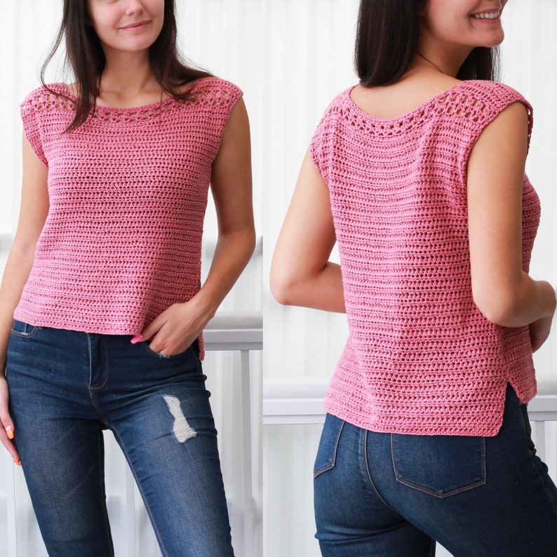 May include: A pink crochet top with a sleeveless design and a crocheted neckline. The top is shown on a model wearing blue jeans.