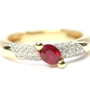 May include: A gold ring with a red ruby gemstone and small diamonds set in the band.