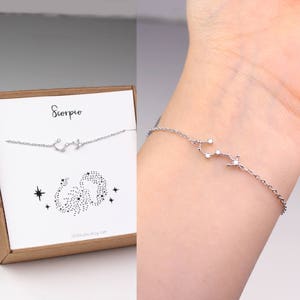 A silver Scorpio zodiac bracelet is hanging on the matching Scorpio card in a gift box (on the left). The photo on the right shows a woman's wrist wearing a silver Scorpio bracelet.