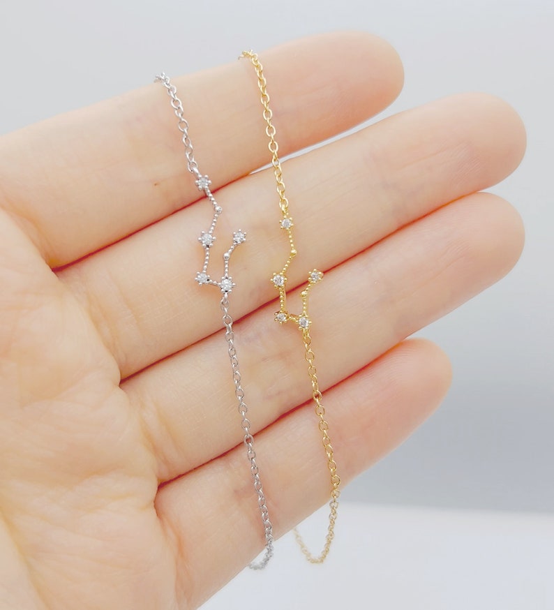 A silver and a gold Aquarius constellation bracelets (left and right).