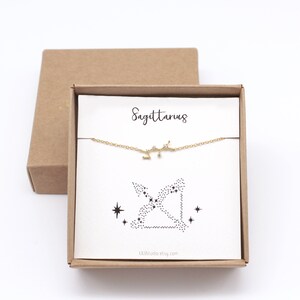 This picture shows a gold Sagittarius zodiac bracelet hanging on the matching Sagittarius card in a gift box.