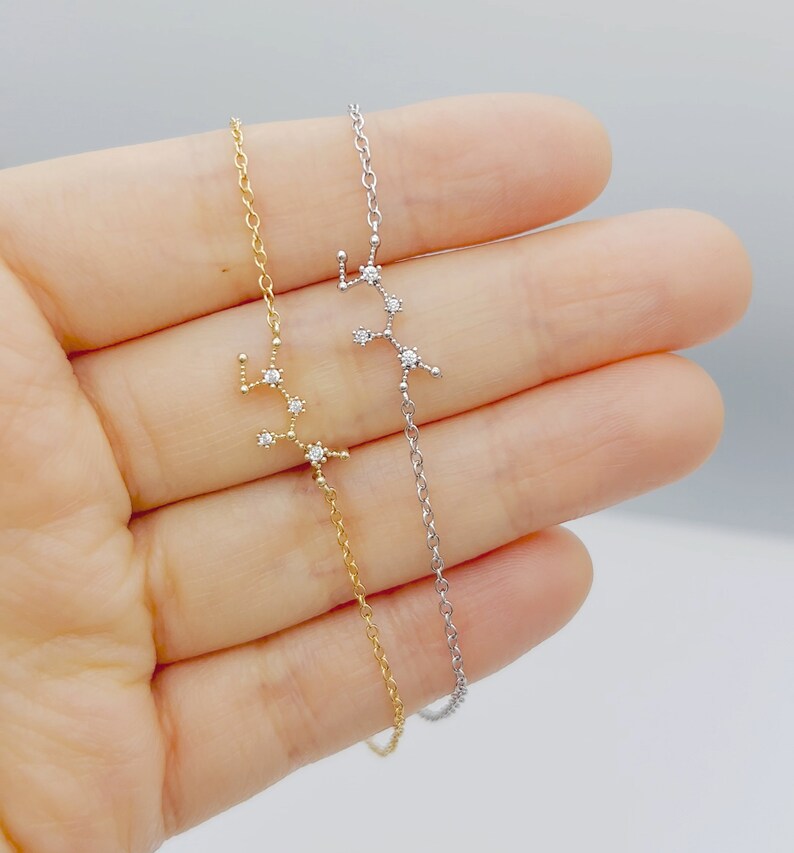 This photo shows a gold and a silver Sagittarius zodiac bracelets (left and right).