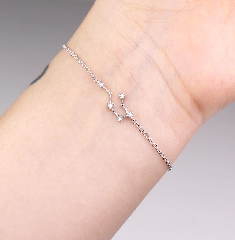 This photo shows the front of a silver Aquarius astrology bracelet.