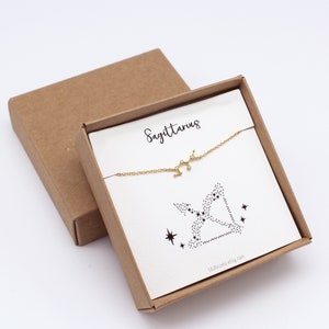 This picture shows a gold Sagittarius bracelet hanging on the matching Sagittarius card in a gift box.