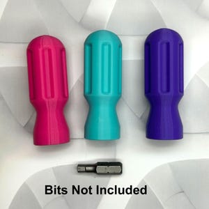 May include: Three colorful screwdriver handles in pink, teal, and purple, with a small metal bit below. The handles have a ribbed design for grip. The text "Bits Not Included" is printed below the bit.