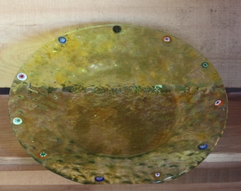 May include: A yellow glass bowl with a textured surface and a decorative rim of colorful glass beads. The bowl is round and shallow.