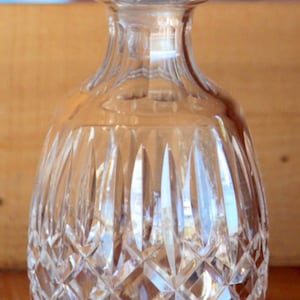 Peut inclure: Une carafe en verre transparent avec un motif en forme de diamant et un bouchon amovible. La carafe est vide.