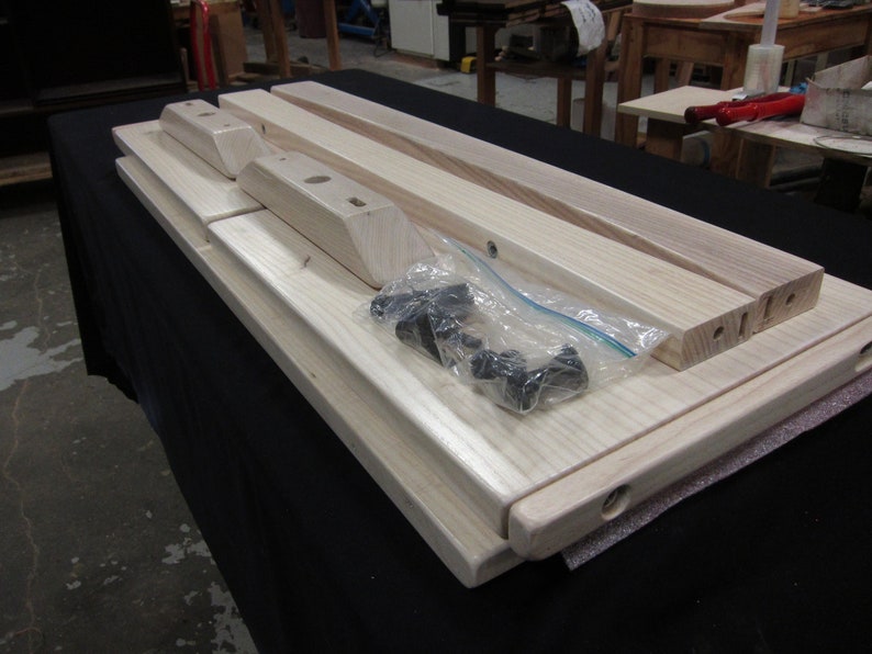 May include: A set of unfinished wooden table legs and top pieces, ready for assembly. The set includes hardware in a clear plastic bag.