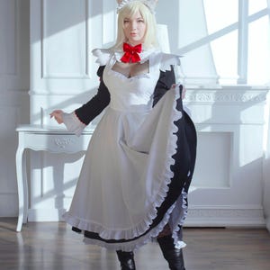 Könnte beinhalten: Ein Cosplay-Outfit mit einem weißen Dienstmädchenkleid mit schwarzen Akzenten, einer roten Schleife und einem Katzenohren-Stirnband. Das Kleid hat einen gerüschten Saum und Ärmel. Die Person trägt schwarze Stiefel. Der Hintergrund ist ein weißer Raum.