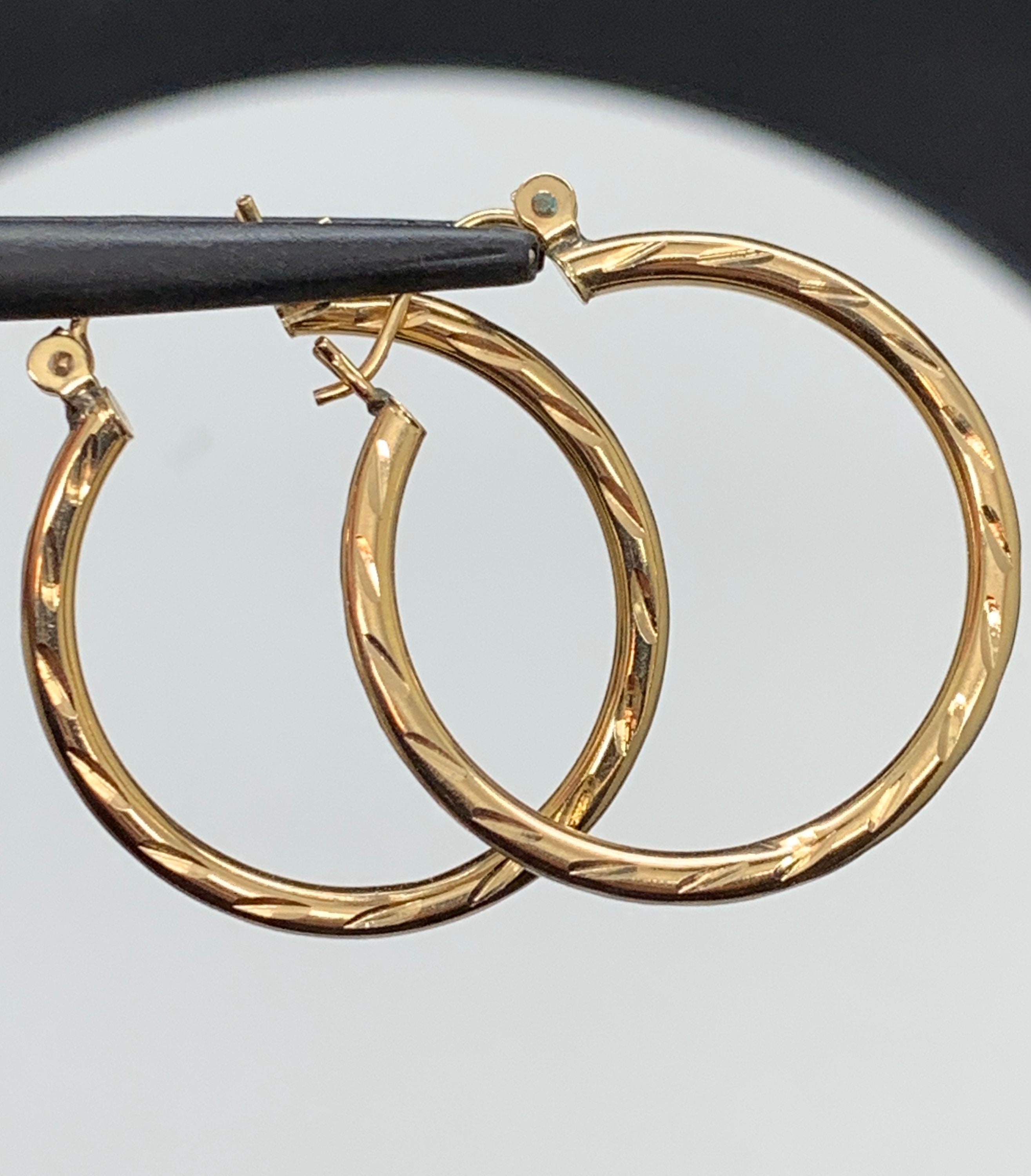 14k gold hoops. Engraved for proper sparkle. One inch diameter.