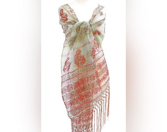 May include: A white sheer shawl with a red and green paisley pattern and fringe trim.