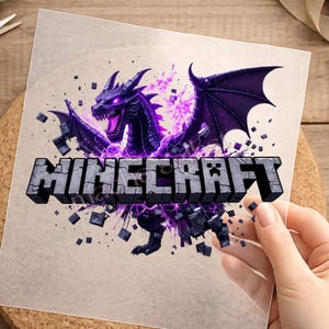 Könnte beinhalten: Ein transparenter Aufkleber mit einem dunkelvioletten Drachen mit leuchtenden Augen und Flügeln, umgeben von violetter Energie und schwebenden dunklen Blöcken. Das Wort MINECRAFT ist in einer großen, blockartigen Steinschrift gedruckt.