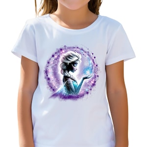 Könnte beinhalten: Ein weißes kurzärmeliges T-Shirt mit einer kreisförmigen Grafik einer blonden Figur mit geflochtener Frisur, die ein blaues Outfit trägt, umgeben von einem violetten und blauen kosmischen Nebeleffekt mit funkelnden Lichtpartikeln und wirbelnden Mustern.
