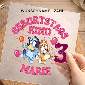 Könnte beinhalten: Ein transparenter Aufkleber mit den Zeichentrickfiguren Bluey und Bingo, dem rosa Schriftzug GEBURTSTAGSKIND, dem Namen MARIE in Rosa, einer großen lila Zahl 3 sowie bunten Luftballons und Konfetti auf einer durchsichtigen Trägerfolie.