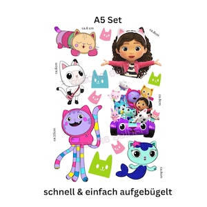 Könnte beinhalten: Ein A5-Set mit bunten Cartoon-Katzen- und Charakterdesigns. Enthält eine Katze mit Gitarre, eine Meerjungfrauenkatze und eine Figur in einem lila Auto. Das Set enthält auch den Text "A5 Set" und "ca. 6 cm" Messungen.