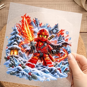Könnte beinhalten: Ein quadratischer Aufkleber mit einer roten Ninja-Figur, die ein leuchtendes orangefarbenes Flammenschwert hält. Die Szene zeigt verschneite Tannen, blaue Eiskristalle, rote Beeren und eine leuchtende Laterne vor einem Hintergrund aus Feuer und Schneeflocken.