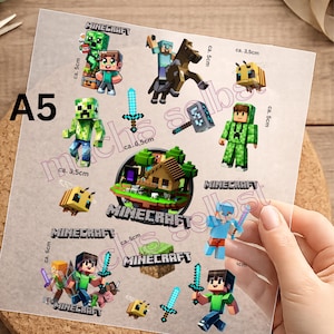 Könnte beinhalten: Ein A5-Bogen mit Minecraft-Aufklebern, die verschiedene Charaktere, Werkzeuge und ein Haus zeigen. Der Bogen enthält einen Creeper, Steve, ein Pferd, Bienen, ein Diamantschwert und eine Spitzhacke mit aufgedruckten Maßen wie ca. 5cm und ca. 3,5cm.