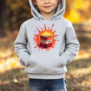 Könnte beinhalten: Hellgrauer Kapuzenpullover mit einem farbenfrohen Grafikdesign eines explodierenden TNT-Blocks. Der TNT-Block ist rot mit weißen Buchstaben "TNT". Die Explosion wird in Orange- und Rottönen dargestellt. Der Hoodie hat eine Kapuze und eine Vordertasche.