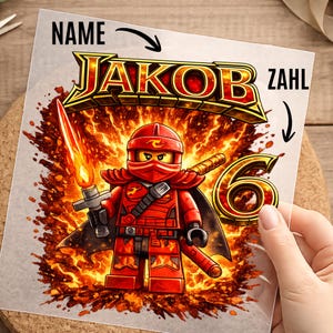 Könnte beinhalten: Eine quadratische Karte mit einer roten Ninja-Figur, die ein flammendes Schwert vor einem feurigen Hintergrund hält. Der Text 'NAME' zeigt auf den Namen 'JAKOB' in goldenen Buchstaben, 'ZAHL' zeigt auf die große goldene Zahl '6' rechts.