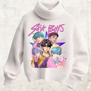 Könnte beinhalten: Weißer Rollkragenpullover mit einer Grafik von fünf Figuren im Anime-Stil mit bunten Haaren. Die Grafik enthält den Text "Saja Boys" in einer rosa, stilisierten Schriftart, vor einem blauen Sternenhintergrund. Der Pullover ist einfarbig weiß.