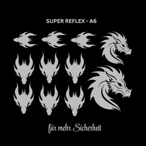 Könnte beinhalten: Ein Bogen mit silbernen reflektierenden Aufklebern auf schwarzem Hintergrund mit verschiedenen Drachenkopfmotiven. Der Text lautet SUPER REFLEX - A6 und für mehr Sicherheit. Die Aufkleber umfassen drei kleine Seitenprofile, sechs Frontansichten und zwei große Seitenprofile.