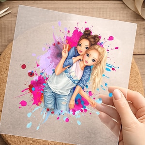 Könnte beinhalten: Illustration von zwei jungen Frauen, die sich umarmen, vor dem Hintergrund farbenfroher Farbspritzer. Eine Frau zeigt das Friedenszeichen. Die Frauen tragen Freizeitkleidung, darunter Jeans und eine Jeansjacke.