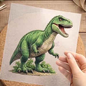 Könnte beinhalten: Detaillierte Illustration eines grünen Tyrannosaurus Rex Dinosauriers mit offenem Maul, das Zähne und einen roten Innenraum zeigt. Der Dinosaurier steht auf einem Flecken grünen Laubes. Das Bild befindet sich auf einem transparenten Blatt.