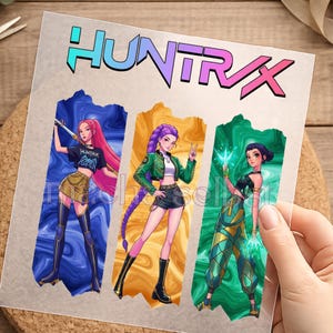 Könnte beinhalten: Ein Blatt mit dem Wort "HUNTRAX" in einer Farbverlaufs-Schriftart. Das Blatt zeigt drei Illustrationen von Frauen in Actionposen, jede mit einem einzigartigen Outfit und Frisur. Die Hintergrundfarben sind Blau, Gold und Grün.