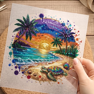 Könnte beinhalten: Ein farbenfrohes Pailletten-Kunstwerk, das eine tropische Strandszene mit Palmen, einem Sonnenuntergang und einer Meeresschildkröte darstellt. Das Kunstwerk weist eine lebendige Farbpalette aus Blau-, Grün-, Orange- und Lilatönen auf, die einen schimmernden Effekt erzeugt. Muscheln sind am Sandstrand verstreut.