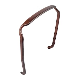 May include: A brown plastic headband for hair. The headband is curved and has a smooth finish.