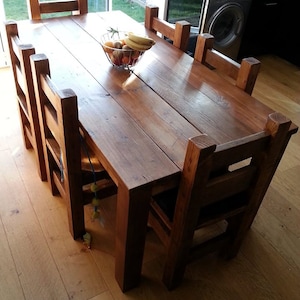 May include: A rustic wooden dining table with six chairs. The table is made of reclaimed wood and has a natural finish. The chairs are also made of wood and have a simple design.