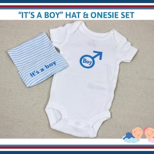 May include: A white onesie with blue "Boy" text and a blue gender symbol. A blue and white striped hat with "It's a boy" text is included.
