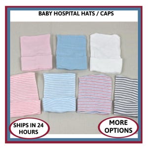 May include: A collection of seven baby hospital hats arranged in two rows. The top row features solid pink, solid blue, and solid white hats. The bottom row includes four striped hats in pink and white, blue and white, pink and blue, and gray and white.