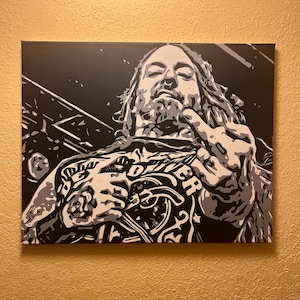 Puede incluir: Pintura de retrato en blanco y negro de una persona con cabello largo y barba. La persona lleva una camisa con un diseño gráfico y está haciendo un gesto con la mano.