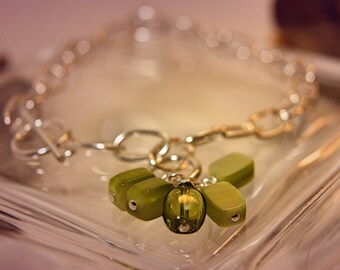 Gorgeous 925 sterling silver charm bracelet adorned with peridot stone .