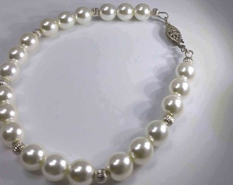 Charming white pearls bracelet mounted with sterling silver beads and claps .