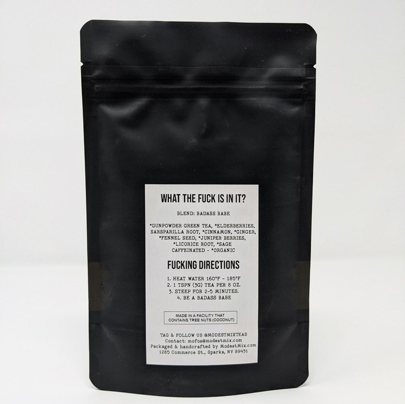 May include: Black tea bag with white text that reads "WHAT THE FUCK IS IN IT?" and "FUCKING DIRECTIONS". The tea blend includes gunpowder green tea, elderberries, and other organic ingredients. The bag is sealed and stands upright.