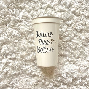 May include: White plastic cup with the text "Future Mrs. Belton" and a gold ring graphic.