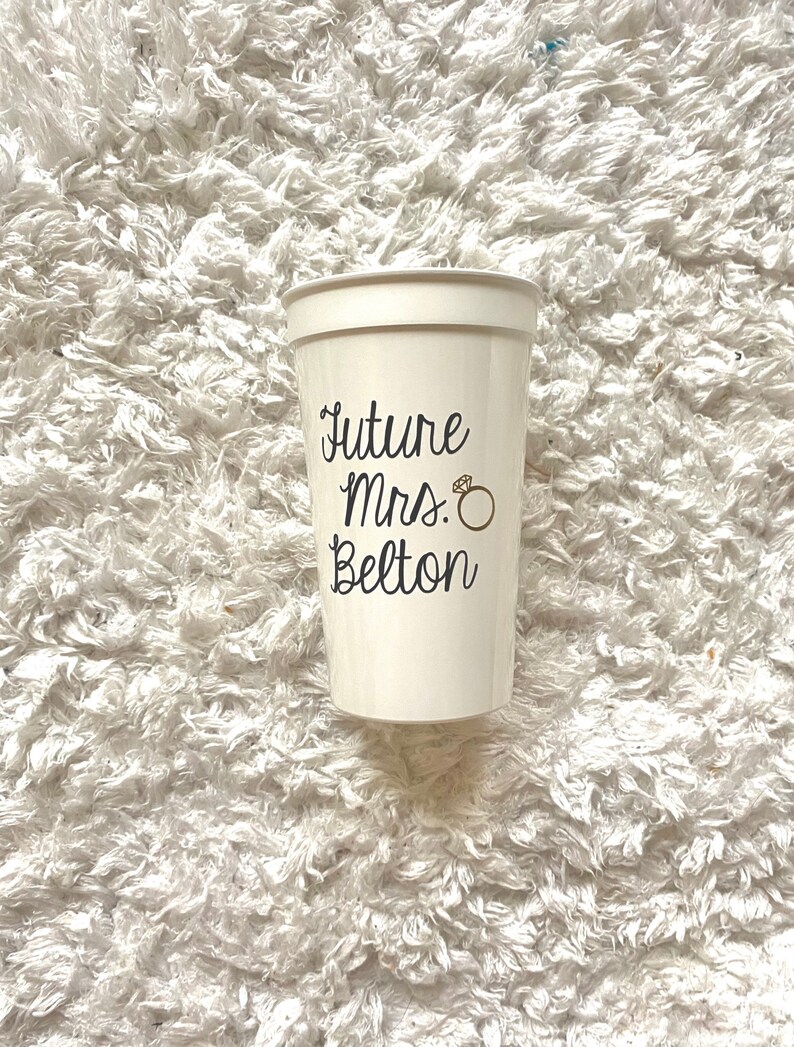 May include: White plastic cup with the text "Future Mrs. Belton" and a gold ring graphic.