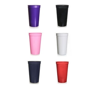 May include: Six plastic cups in different colors: purple, black, pink, white, navy blue, and red. The cups are all the same size and shape.